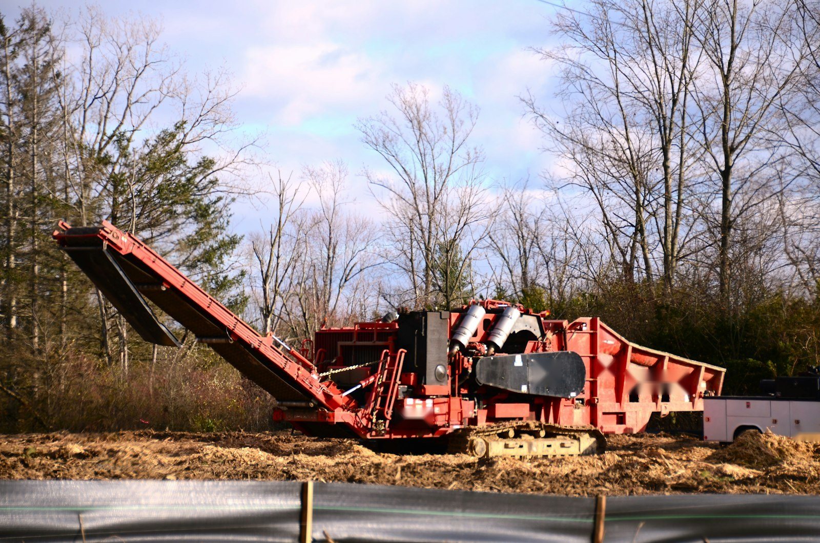 Limbs being fed into a wood chipper at the curb